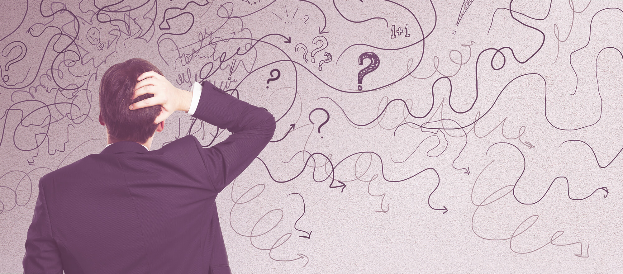 Startup recruiter facing confusion, scratching his head in front of a wall filled with question marks and arrows, symbolising challenges in recruitment agencies.