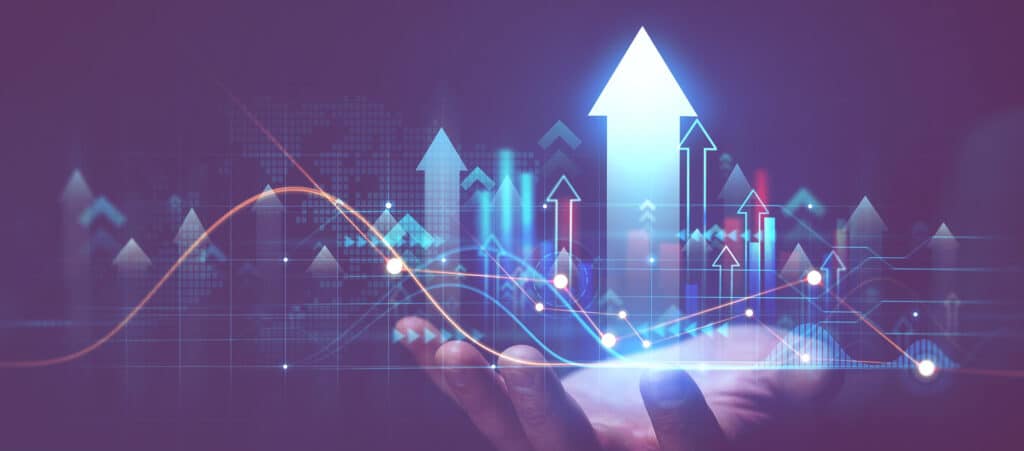 A hand cradling a digital projection of ascending stock charts and a large upward arrow, symbolising maximum business valuation, financial growth, and successful agency sales for recruitment firms.