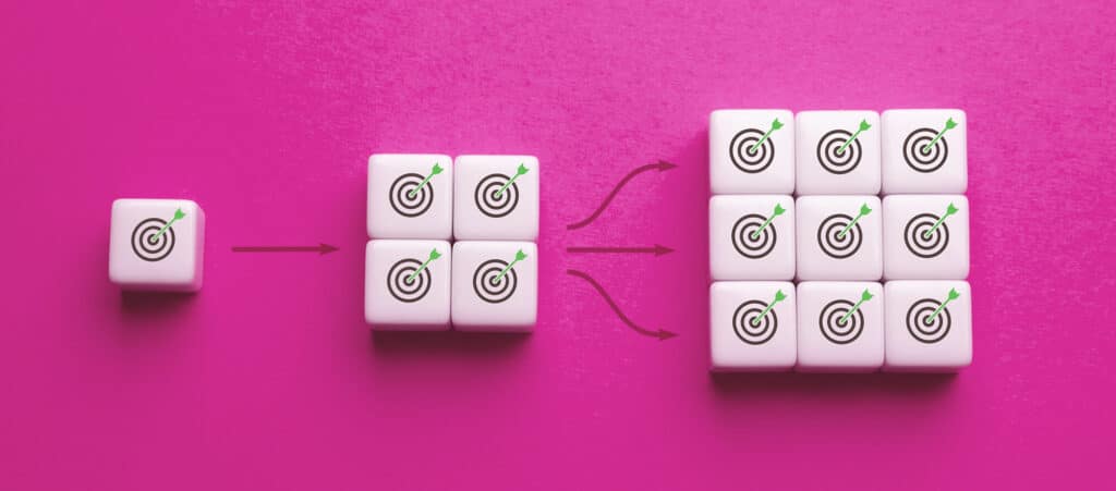A sequence of white blocks on a pink background showing a single target multiplying into many, illustrating how recruitment agencies can scale and unlock more opportunities through CONTRACT PLACEMENTS