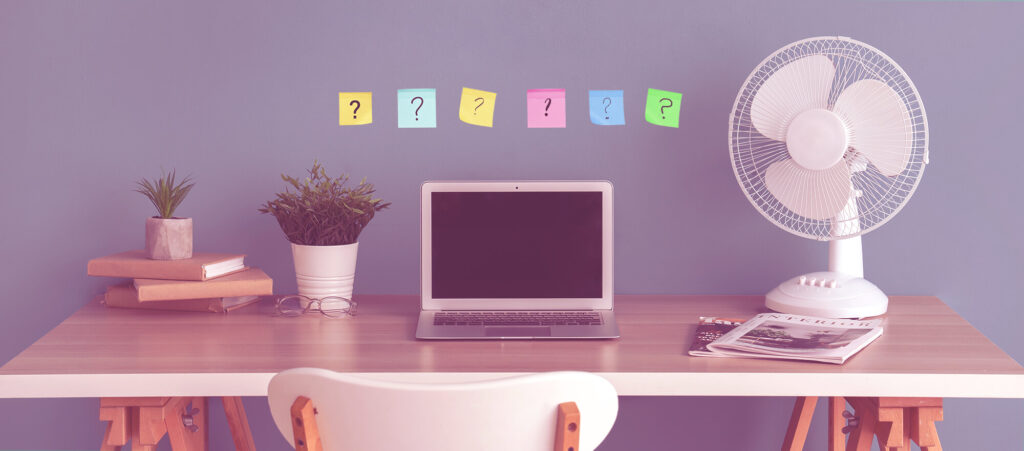 Office workspace with laptop and question notes representing key considerations for starting a contract desk and managing contractor funding solutions